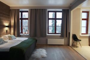 um quarto com uma cama e duas janelas em Hotel Metsähirvas em Rovaniemi