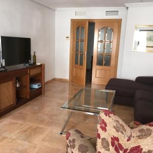a living room with a glass table and a couch at Apartamento en Alicante, Plaza de España, zona Mercado, AA in Alicante