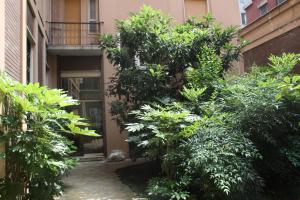 een tuin met bomen en struiken voor een gebouw bij La casa-atelier in Milaan