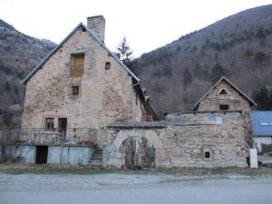 an old stone building in front of a mountain at Au Fil des Saisons in Les Cotes de Corps