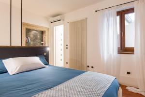 um quarto com uma cama azul e uma janela em Casa Savio em Verona