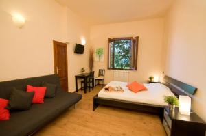 ein Wohnzimmer mit einem Bett und einem Sofa in der Unterkunft Dolce Notte in Pisa