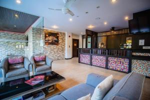 a living room with two couches and a table at Ratana Hotel Chalong in Rawai Beach