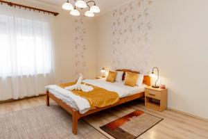 a bedroom with a bed and a large window at Almafa Apartmanház in Eger