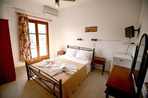 A bed or beds in a room at To Gefyraki Rooms