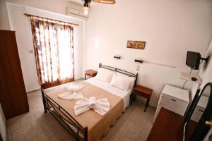 A bed or beds in a room at To Gefyraki Rooms