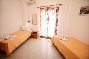 A bed or beds in a room at To Gefyraki Rooms
