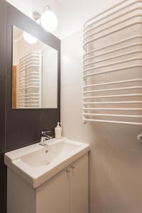 a bathroom with a white sink and a mirror at Nobel Suites in Kraków