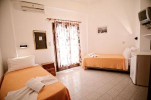 A bed or beds in a room at To Gefyraki Rooms