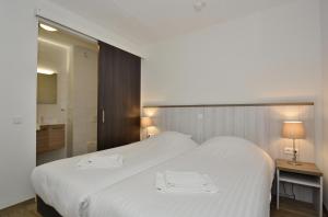 ein Schlafzimmer mit einem großen weißen Bett mit zwei Handtüchern darauf in der Unterkunft Hotel Graaf Bernstorff in Schiermonnikoog