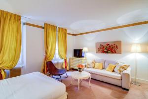 a hotel room with a couch and a table at Villa Escudier Appart-hôtel in Boulogne-Billancourt