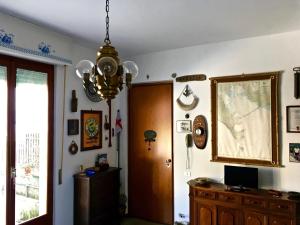 Habitación con lámpara de araña, escritorio y puerta. en Portovenere Apartment G.H., en Portovenere