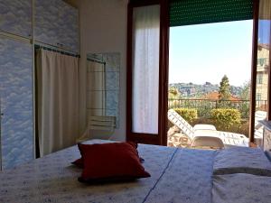 1 dormitorio con 1 cama y vistas a un balcón en Portovenere Apartment G.H., en Portovenere