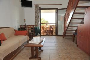 a living room with a couch and a table at Villa Maraki in Agia Paraskevi