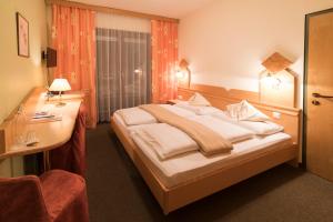 a hotel room with a bed and a desk at Hotel Vital Bad Bleiberg in Bad Bleiberg