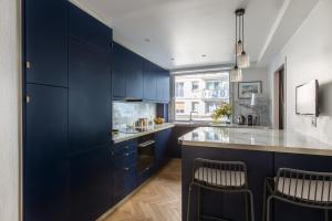 a kitchen with navy blue cabinets and a counter at Veeve - Bois de Boulogne Retreat in Paris