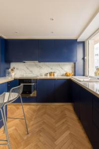 a kitchen with blue cabinets and a chair in it at Veeve - Bois de Boulogne Retreat in Paris