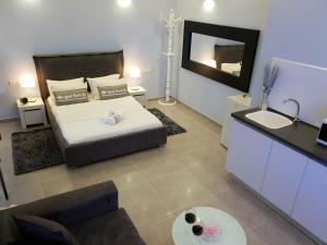 een slaapkamer met een bed en een badkamer met een wastafel bij Spat Hotel Ashdod in Ashdod