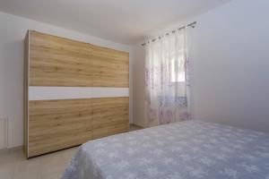 a bedroom with a large bed and a large wooden cabinet at Apartment Angela in Cunski