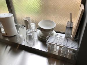 那覇市にあるサンチャゴゲストハウス那覇のキッチンカウンター(トイレ、食器付) +21枚の写真