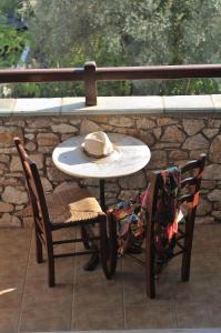 a hat sitting on a table with two chairs at Villa Maraki in Agia Paraskevi