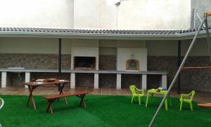 patio z zieloną trawą, stołem i krzesłami w obiekcie Casa El lince de Granadilla, Norte provincia Cáceres, WIFI, Parque infantil, HIDROMASAJE, garaje, LAVAVAJILLAS w mieście Zarza de Granadilla