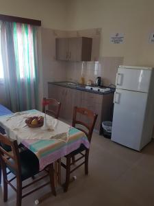 a kitchen with a table and a white refrigerator at Eleni Apartments in Ayia Napa