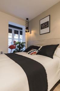 a bedroom with a black and white bed and a window at Cantalojas by Staynnapartments in Bilbao