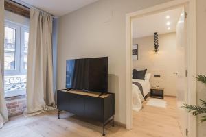 a living room with a television and a bed at Cantalojas by Staynnapartments in Bilbao +6 photos