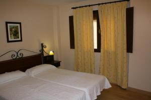 a bedroom with a bed and a window at Hotel Rural Huerta del Laurel in Monachil