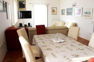 a living room with a table and a couch at Apartments Marinović 3462 in Supetar