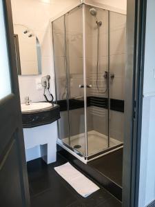 W łazience znajduje się szklana kabina prysznicowa i umywalka. w obiekcie Hotel Tara w Kielcach