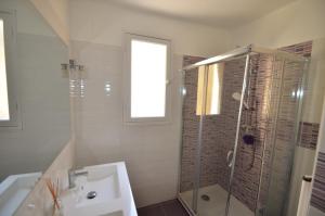 La salle de bains blanche est pourvue d'une douche et d'un lavabo. dans l'établissement 4 Rue Guigonis, à Nice
