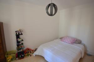 4 Rue Guigonis في نيس: غرفة نوم بسرير ابيض ومخدة وردية