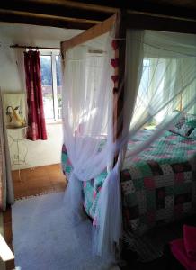 a bedroom with a bed with a canopy at Casa da Casimira in Miranda do Corvo