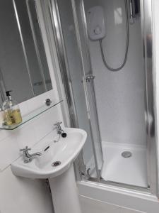 a white bathroom with a sink and a shower at Town House Bridport Dorset in Bridport