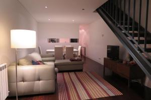 een woonkamer met een bank en een trap bij PATEO LUSO - Cozy Apartment City Center in Porto