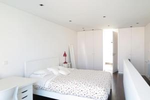 een witte slaapkamer met een bed en witte kasten bij PATEO LUSO - Cozy Apartment City Center in Porto