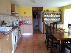 a kitchen with a table and a dining room at Casa da Casimira in Miranda do Corvo