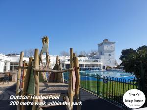 a resort with a pool with a rope swing at Lazy Bear, 25 Arne View in Poole