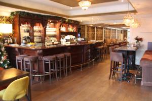 a bar in a restaurant with bar stools at Hotel restaurant Stad Munster in Winterswijk +27 photos