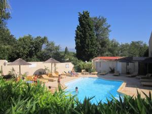 a swimming pool with people sitting around it at Eco-Lodge Lou Pantaï in Le Pradet