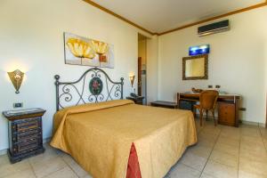 a bedroom with a bed and a desk and a table at Hotel Il Faro Della Guitgia Tommasino in Lampedusa