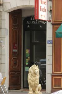 posąg lwa siedzącego przed budynkiem w obiekcie Hôtel Foch w mieście Lyon