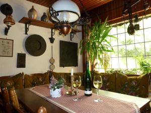 a dining room table with wine glasses and a lamp at Alte Weinstuben Steinfelder Hof Garni in Ellenz-Poltersdorf