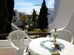 een tafel met een fles wijn en twee stoelen bij Apartamentos São Rafael - Albufeira, Algarve in Albufeira