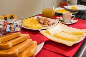 a table topped with plates of breakfast foods and orange juice at Hotel Cannaregio 2357 in Venice