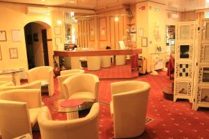 リヨンにあるオテル フォッシュの白い椅子とテーブル、カウンターが備わる客室です。