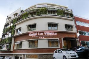 a white car parked in front of a building at Hotel La Villette in Antananarivo