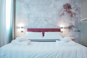 a bedroom with two beds and a large painting on the wall at Hotel Cannaregio 2357 in Venice